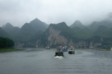 Ships cruise down the Li River in excrable weather*